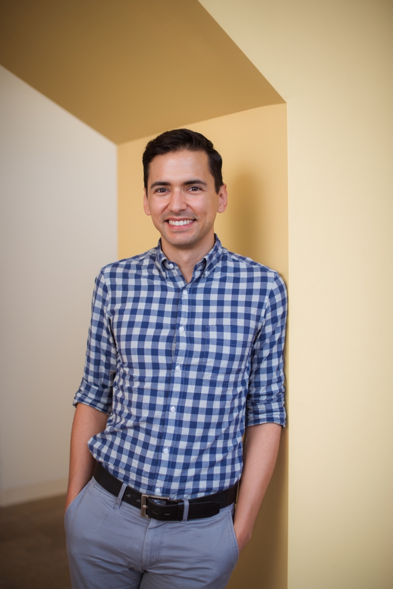 Sebastian Lourido stands smiling in an alcove.