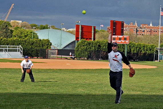 A man throws a softball.