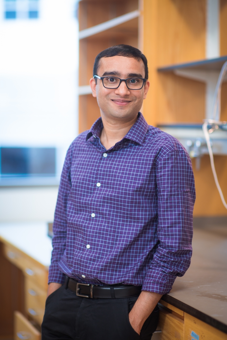 Ankur Jain stands smiling in his lab.