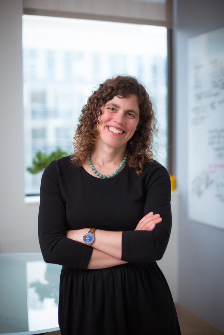 Mary Gehring stands smiling in front of a window.