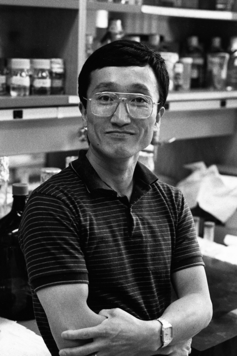 A man stands in a lab, arms folded.