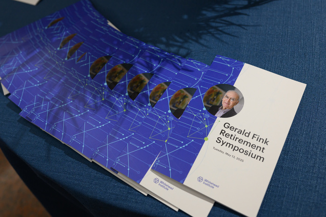 Programs for the "Gerald Fink Retirement Symposium" laid out on a table