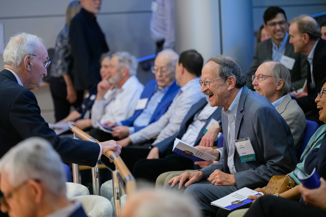 Fink talking to an old friend in the audience, who is leaning forward towards him and smiling