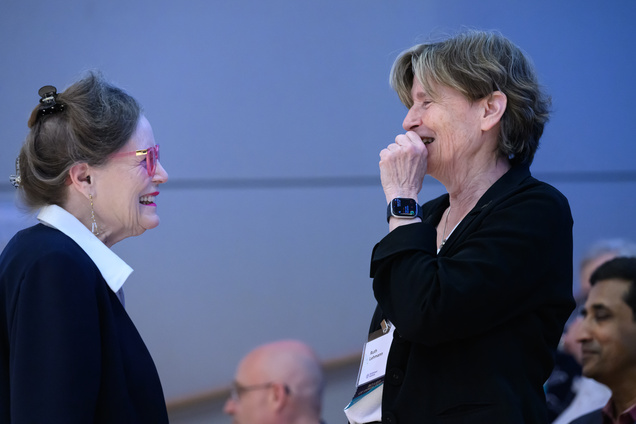 Two women in conversation, stnading near the audience