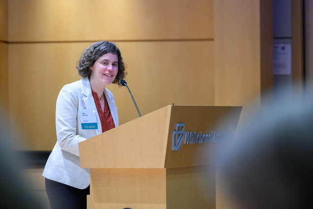 A woman with the nametag "Mary Gehring" speaks from the podium