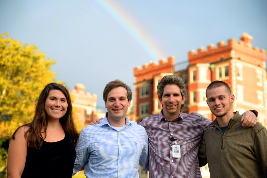 Whitehead Institute Fellow Kipp Weiskopf and group pose in front of the rainbow.
