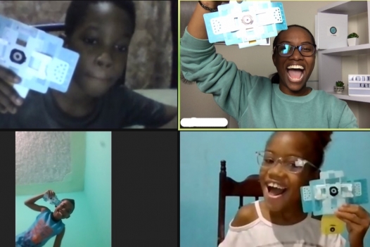 Students on a Zoom call holding up foldscopes